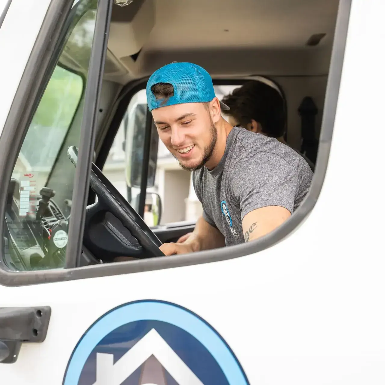 bek-mover-smiling-inside-moving-truck-cab Smiling man in truck cab