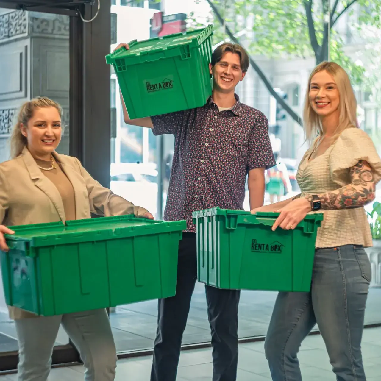 happy customers carrying stl rentabox bins in lobby