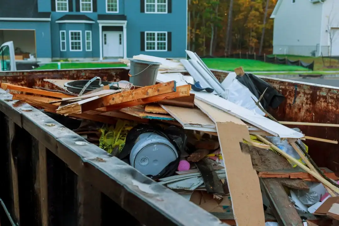 Construction debris in dumpster near houses